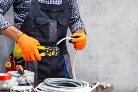 Electrician worker stripping insulation of wires