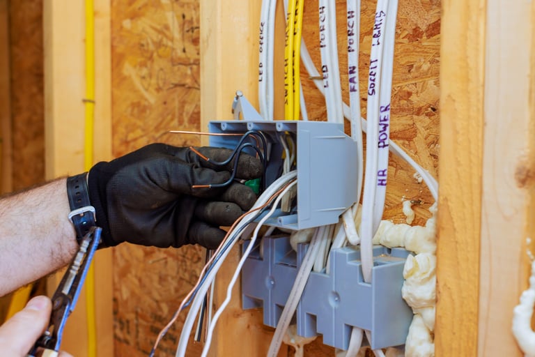 Electrician connects wires inside circuit box